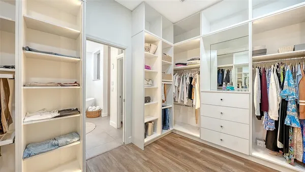 a view of walk in closet and bedroom