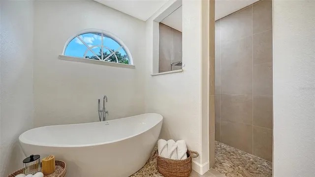 a white bath tub sitting next to a white toilet and a shower