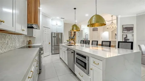a large kitchen with stainless steel appliances granite countertop a sink a stove and a refrigerator