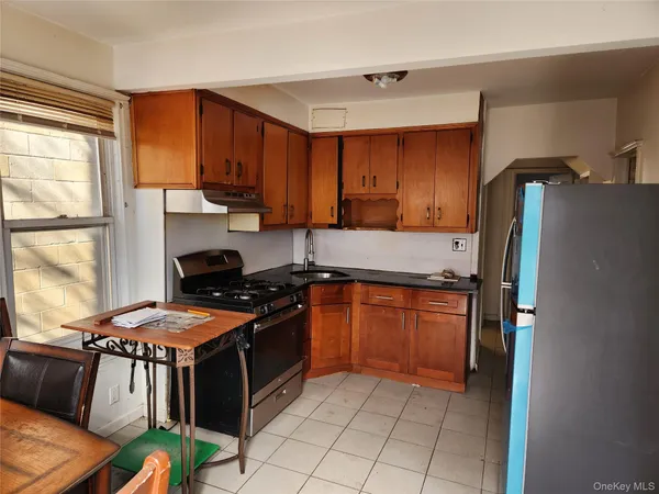 a kitchen with stainless steel appliances granite countertop a stove a refrigerator and a stove top oven