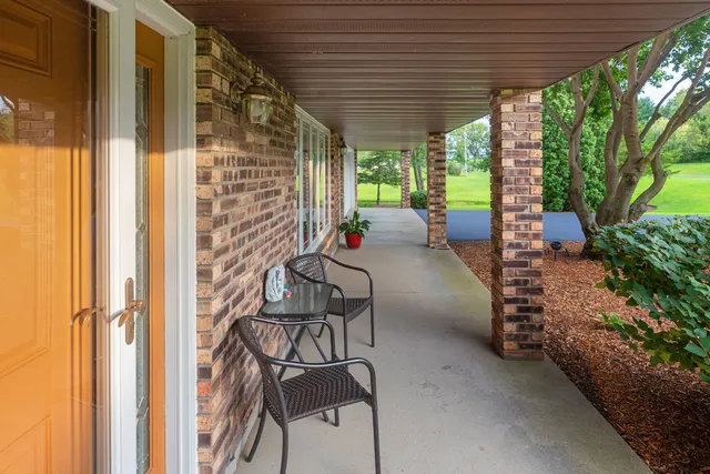 a view of a patio with table and chairs potted plants and floor to ceiling window