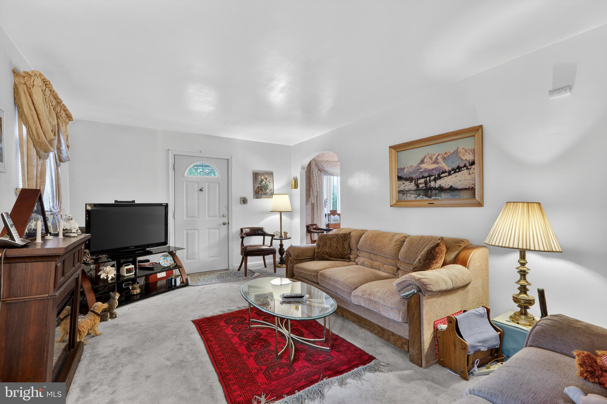 1424 Burmont Road Havertown, PA 19083 - Photo 5 of 37 a living room with furniture and a flat screen tv with a bookshelf