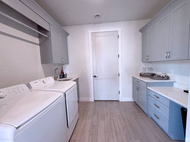 429 East Treasure Road Washington, UT 84780 - Photo 17 of 36 Laundry room featuring light wood-style flooring, washer and clothes dryer, and cabinet space