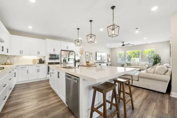 a large white kitchen with lots of counter space wooden floor and appliances
