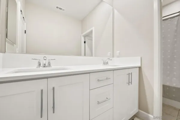 a spacious bathroom with a granite countertop sink mirror and a bathtub