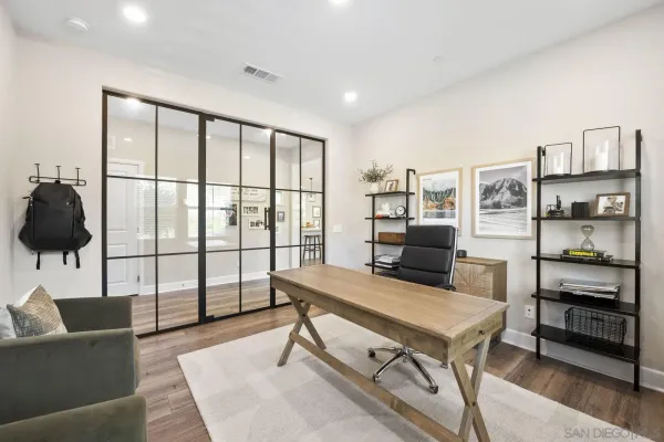 a view of a workspace with furniture and a window