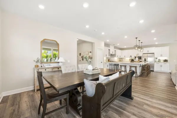 a kitchen with stainless steel appliances kitchen island granite countertop a table chairs and a refrigerator