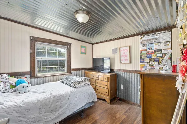 a bedroom with a bed dresser and a window