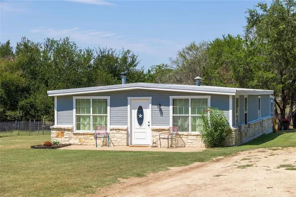 a view of a house with a patio and a yard