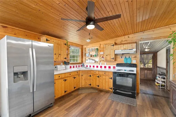 a kitchen with stainless steel appliances granite countertop a refrigerator and wooden floor