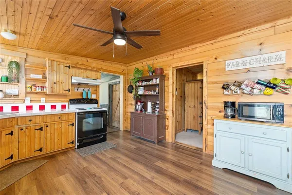 a kitchen that has a lot of cabinets and wooden floor