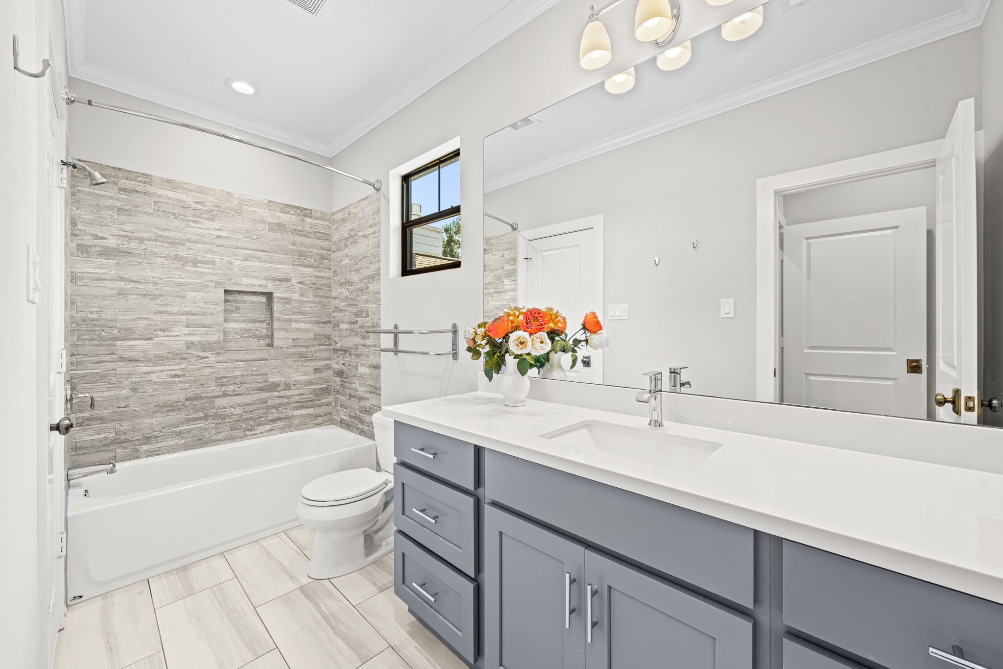1013 Martin Street Houston, TX 77018 - Photo 34 of 46 Versatile bath for secondary bedroom #3 w/hall & bedroom access, vanity storage, & tub/shower combo w/tile surround & built-in niche. Expansive vanity.