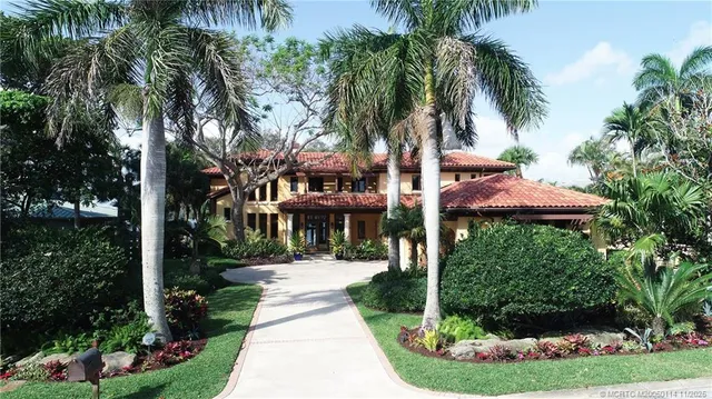 a view of a park that has a sign board large trees
