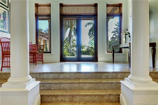 a open kitchen with stainless steel appliances granite countertop a table chairs and a large window