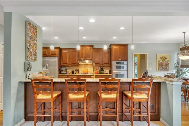 a large kitchen with stainless steel appliances lots of counter space and a sink