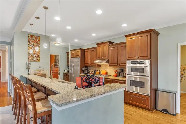 a kitchen with granite countertop wooden cabinets stainless steel appliances and a counter space
