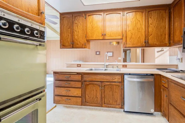 a kitchen with a sink a refrigerator and a stove top oven