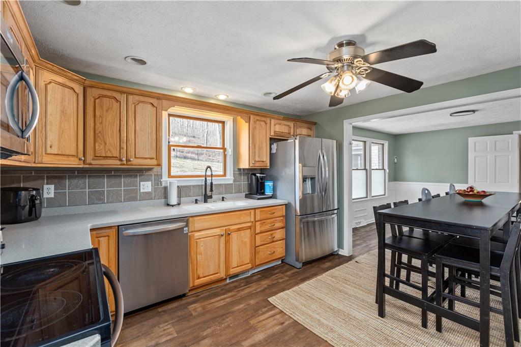 282 Snowden Road Hookstown, PA 15050 - Photo 8 of 25 a kitchen with stainless steel appliances granite countertop a sink a stove a refrigerator cabinets and dining table