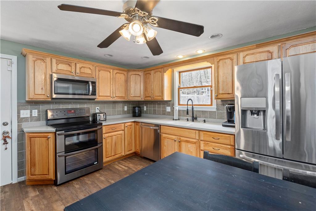 282 Snowden Road Hookstown, PA 15050 - Photo 9 of 25 a kitchen with stainless steel appliances granite countertop a stove top oven a refrigerator a sink and dishwasher with wooden floor