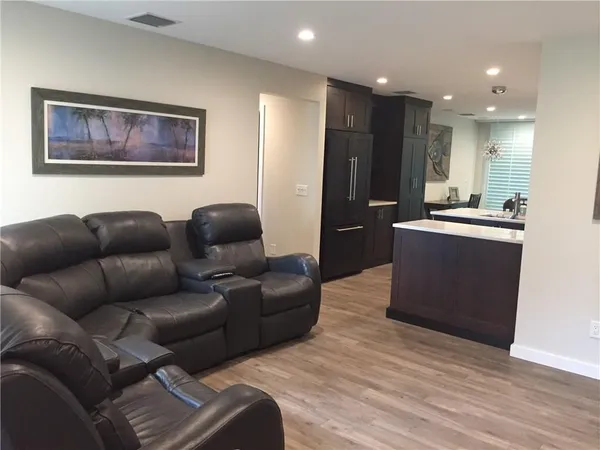 a living room with furniture and a refrigerator