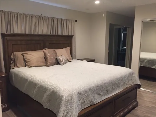 a large bed sitting in a bedroom next to a window