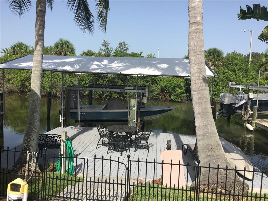 1953 Robalo Drive Vero Beach, FL 32960 - Photo 10 of 12 a view of a patio with table and chairs potted plants with wooden floor