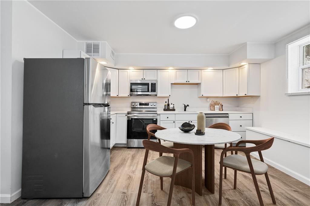 3005 Walton Road Finleyville, PA 15332 - Photo 7 of 31 a kitchen with stainless steel appliances a refrigerator a stove a sink and white cabinets with wooden floor