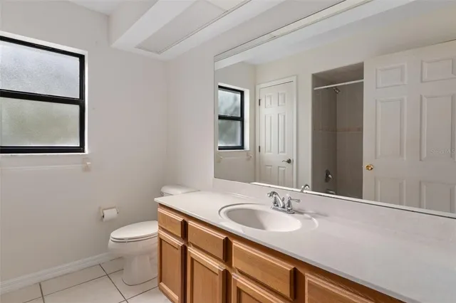 a bathroom with a granite countertop sink a toilet and mirror