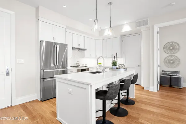 a kitchen with stainless steel appliances a table chairs and refrigerator
