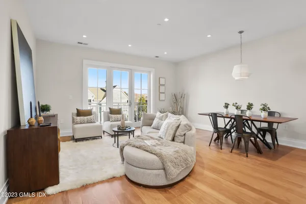 a living room with furniture a wooden floor and a chandelier