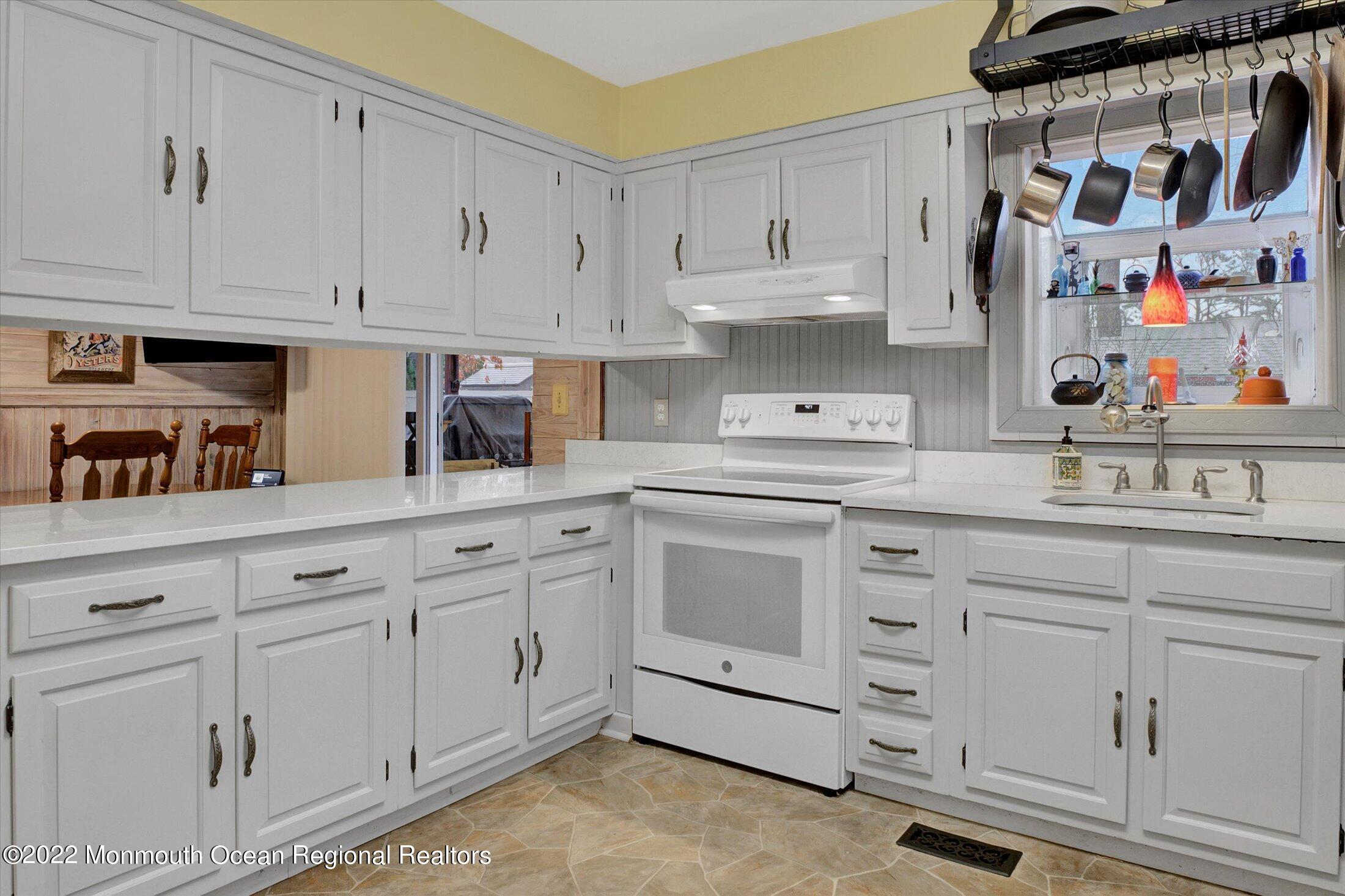 156 Topside Road Manahawkin, NJ 08050 - Photo 5 of 19 a kitchen with white cabinets and white appliances