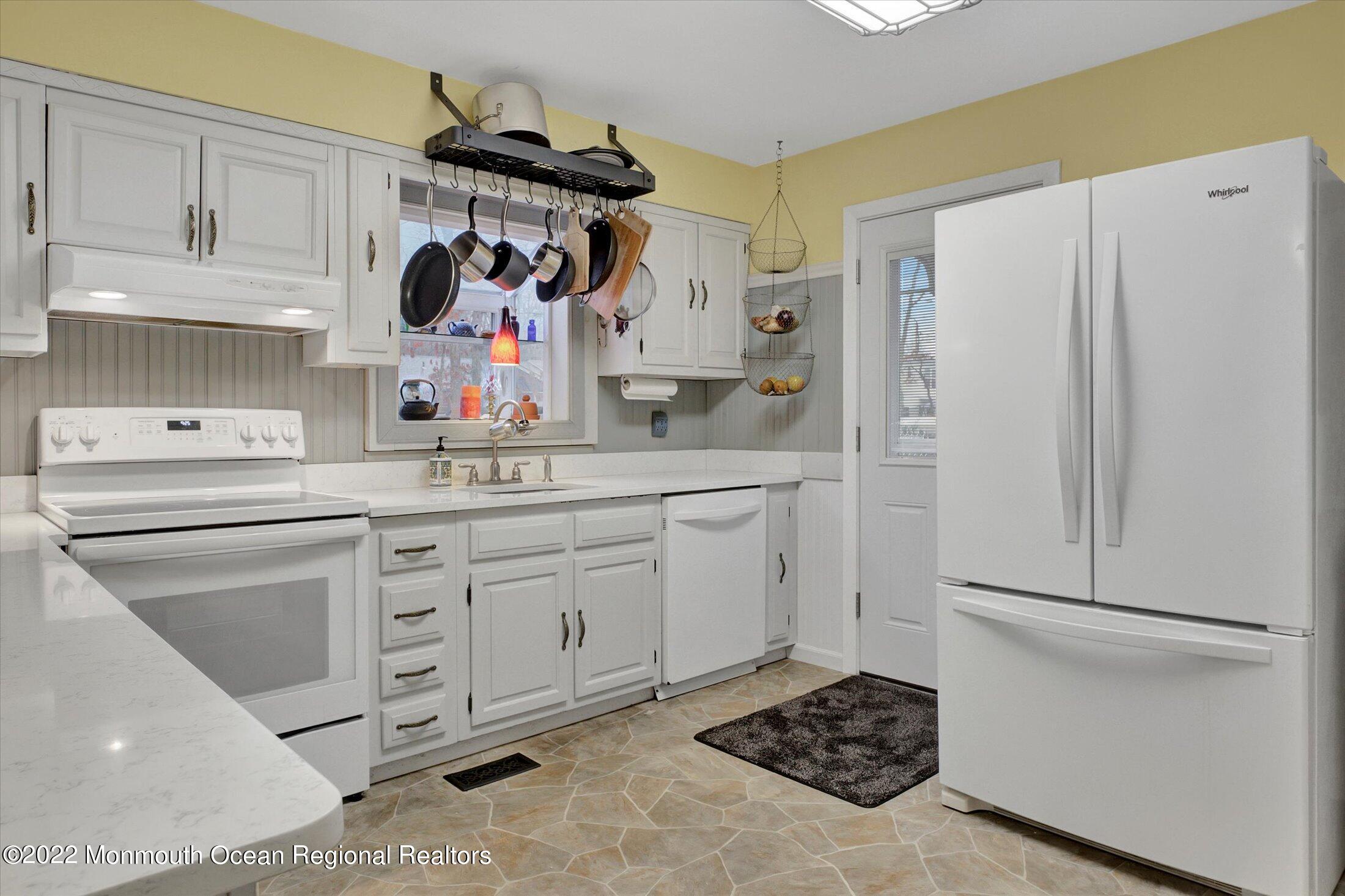 156 Topside Road Manahawkin, NJ 08050 - Photo 6 of 19 a kitchen with white cabinets and white appliances