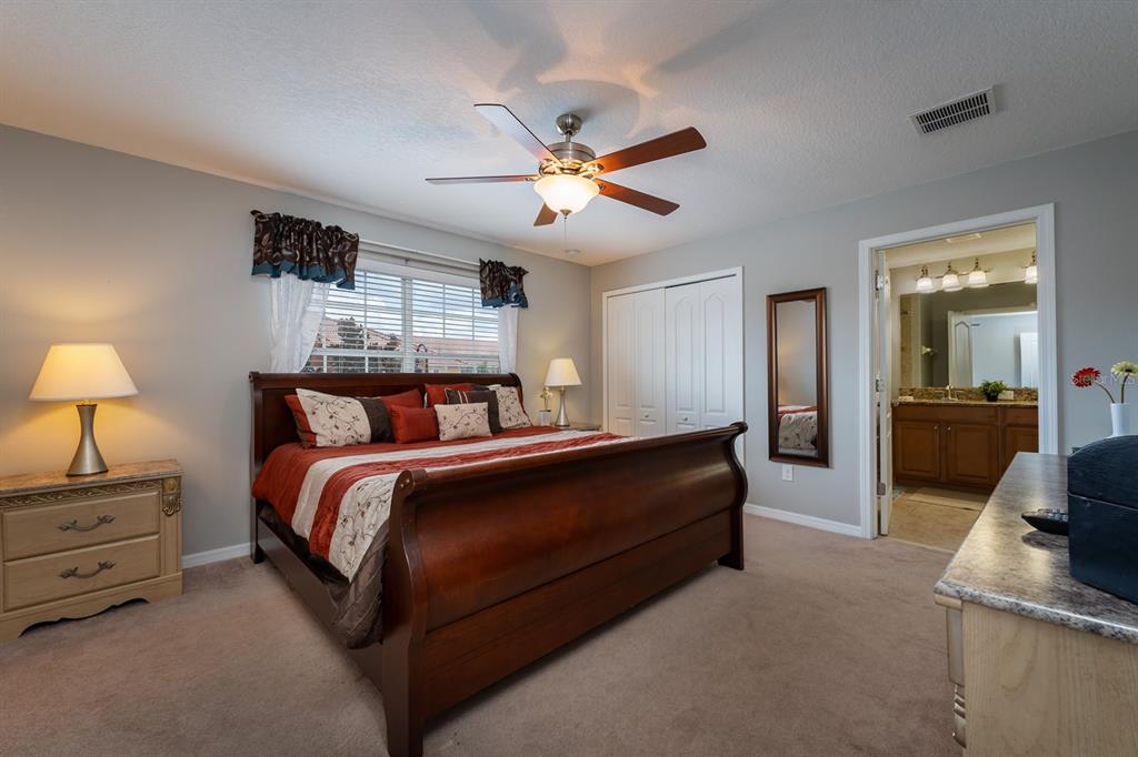 8957 Cat Palm Road Kissimmee, FL 34747 - Photo 17 of 25 a bedroom with bed and a chandelier