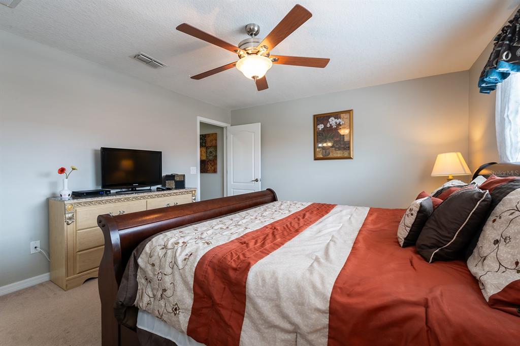 8957 Cat Palm Road Kissimmee, FL 34747 - Photo 18 of 25 a bedroom with a bed and a flat screen tv
