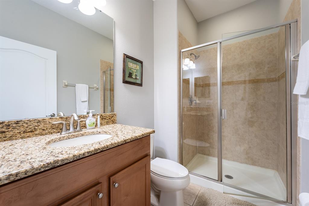 8957 Cat Palm Road Kissimmee, FL 34747 - Photo 2 of 25 a bathroom with a granite countertop sink toilet and shower