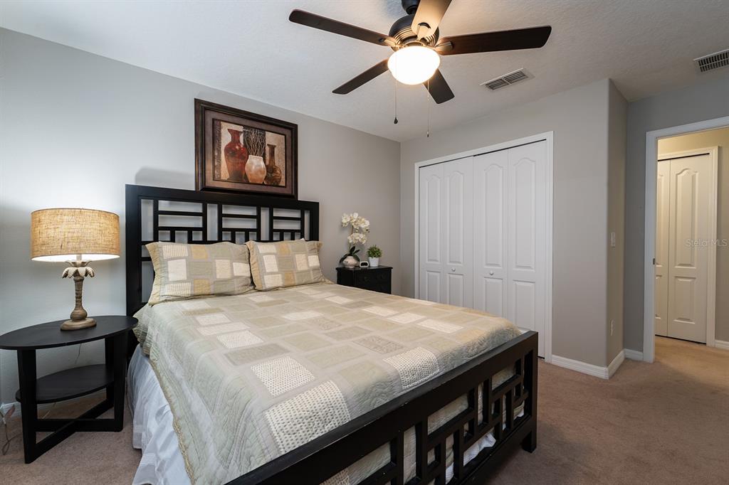 8957 Cat Palm Road Kissimmee, FL 34747 - Photo 21 of 25 a bedroom with a bed and a lamp on dresser