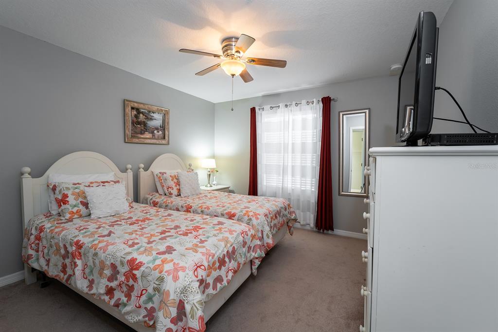 8957 Cat Palm Road Kissimmee, FL 34747 - Photo 22 of 25 a bedroom with a bed and a chandelier