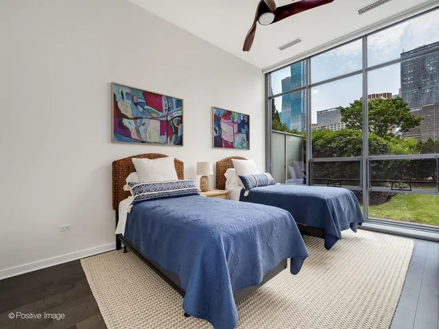 a bedroom with two beds and a large window