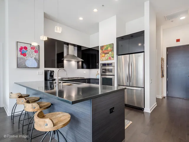 a kitchen with stainless steel appliances granite countertop a refrigerator a stove and a sink