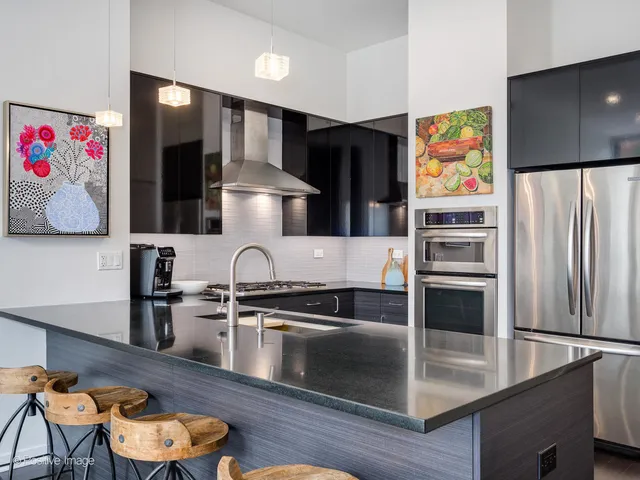 a kitchen with stainless steel appliances granite countertop a refrigerator and a stove top oven