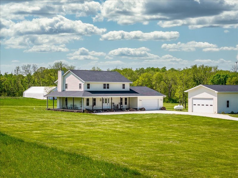 a view of a house with a big yard and large trees