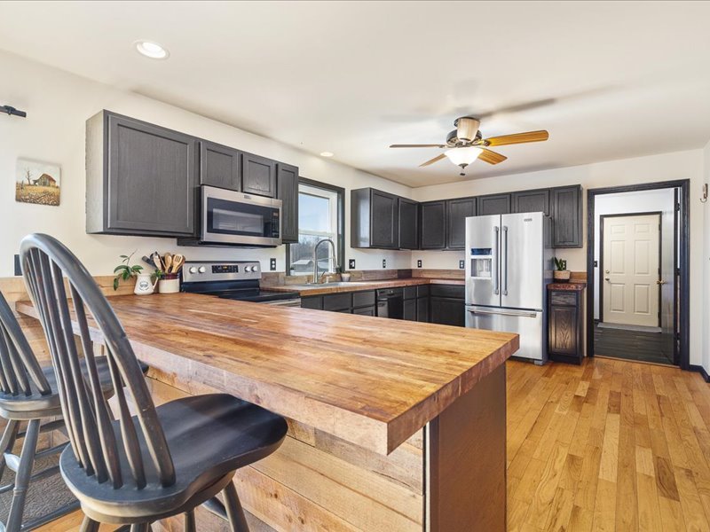 911.41 Melugins Compton, IL 61318 - Photo 19 of 67 a kitchen with stainless steel appliances kitchen island granite countertop a table chairs and a refrigerator