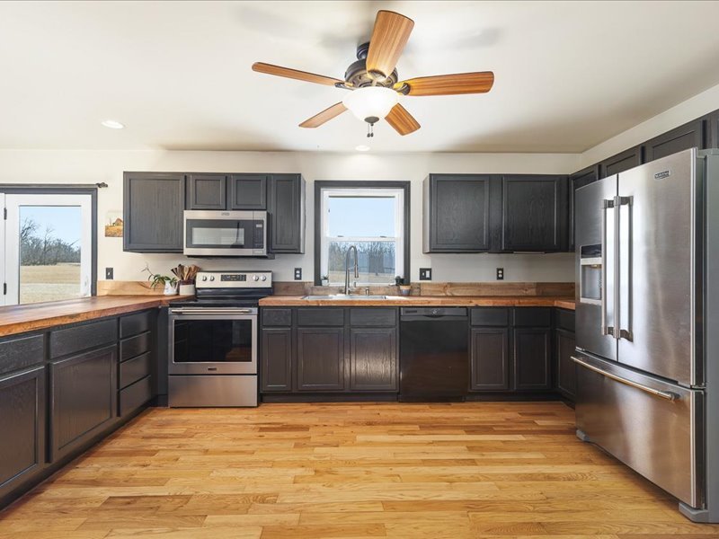 911.41 Melugins Compton, IL 61318 - Photo 20 of 67 a large kitchen with granite countertop a refrigerator and a stove top oven