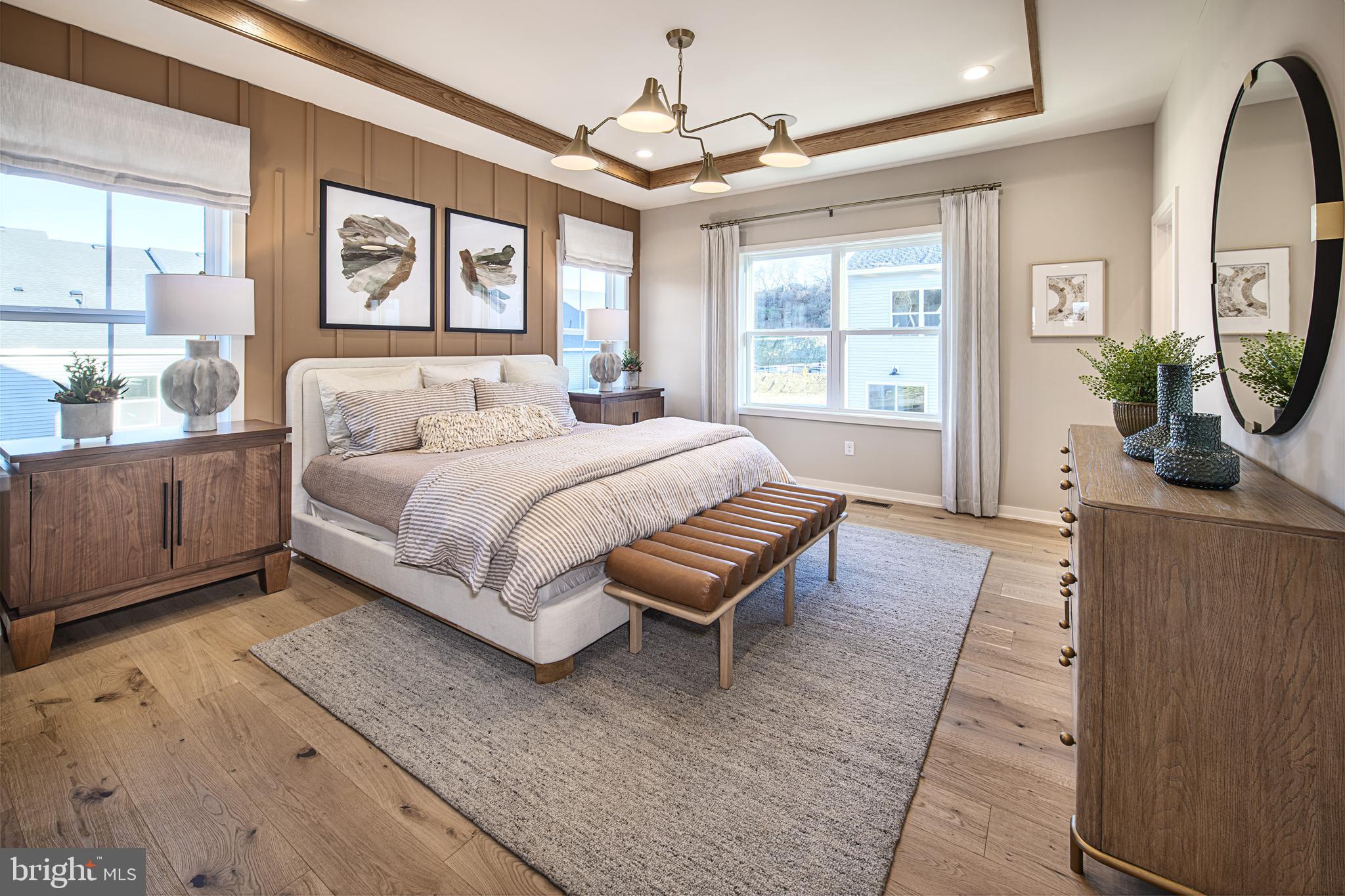 606 Kemlyn Road, Unit HOMESITE 184 Malvern, PA 19355 - Photo 15 of 15 a spacious bedroom with a large bed a chandelier and windows