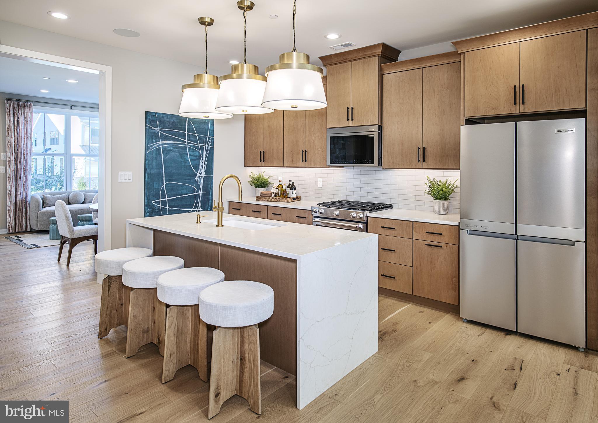 606 Kemlyn Road, Unit HOMESITE 184 Malvern, PA 19355 - Photo 10 of 15 a kitchen with stainless steel appliances granite countertop a stove a refrigerator a kitchen island a sink dishwasher and white cabinets with wooden floor