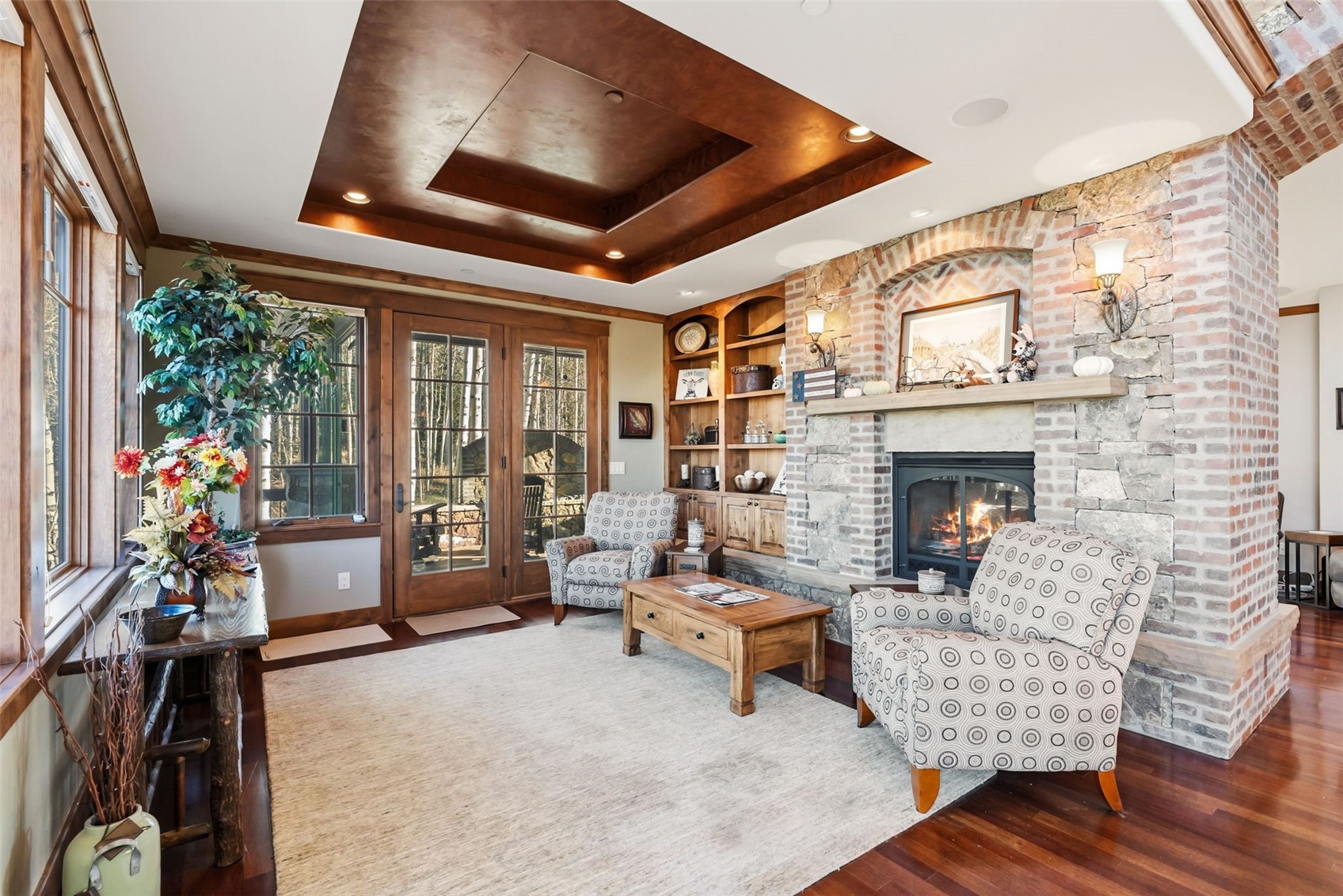 2140 Hunter's Knob Road Silverthorne, CO 80498 - Photo 6 of 46 Living area with a tray ceiling, a fireplace, wood finished floors, and built in shelves