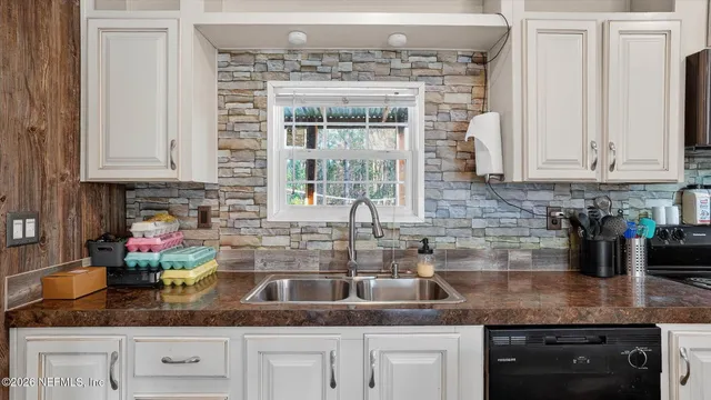 a kitchen with granite countertop a sink stainless steel appliances and cabinets