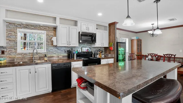 a kitchen with granite countertop a sink a counter top space appliances and cabinets