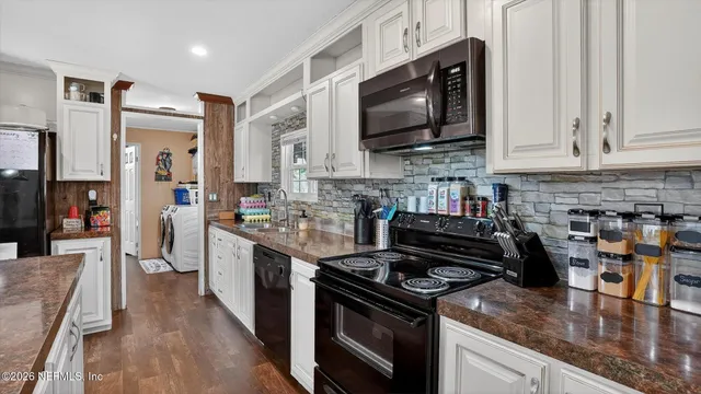 a kitchen with stainless steel appliances granite countertop a stove top oven a sink dishwasher and a refrigerator with wooden floor