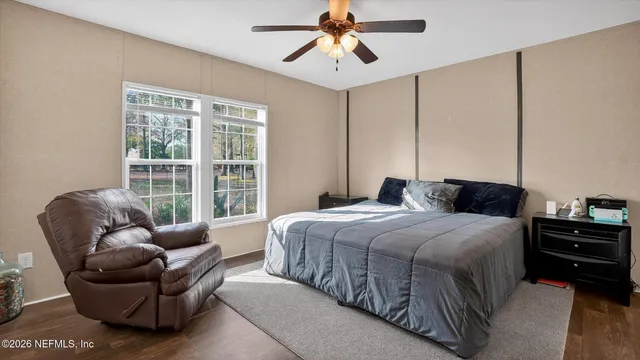 a bedroom with a bed a couch and a window